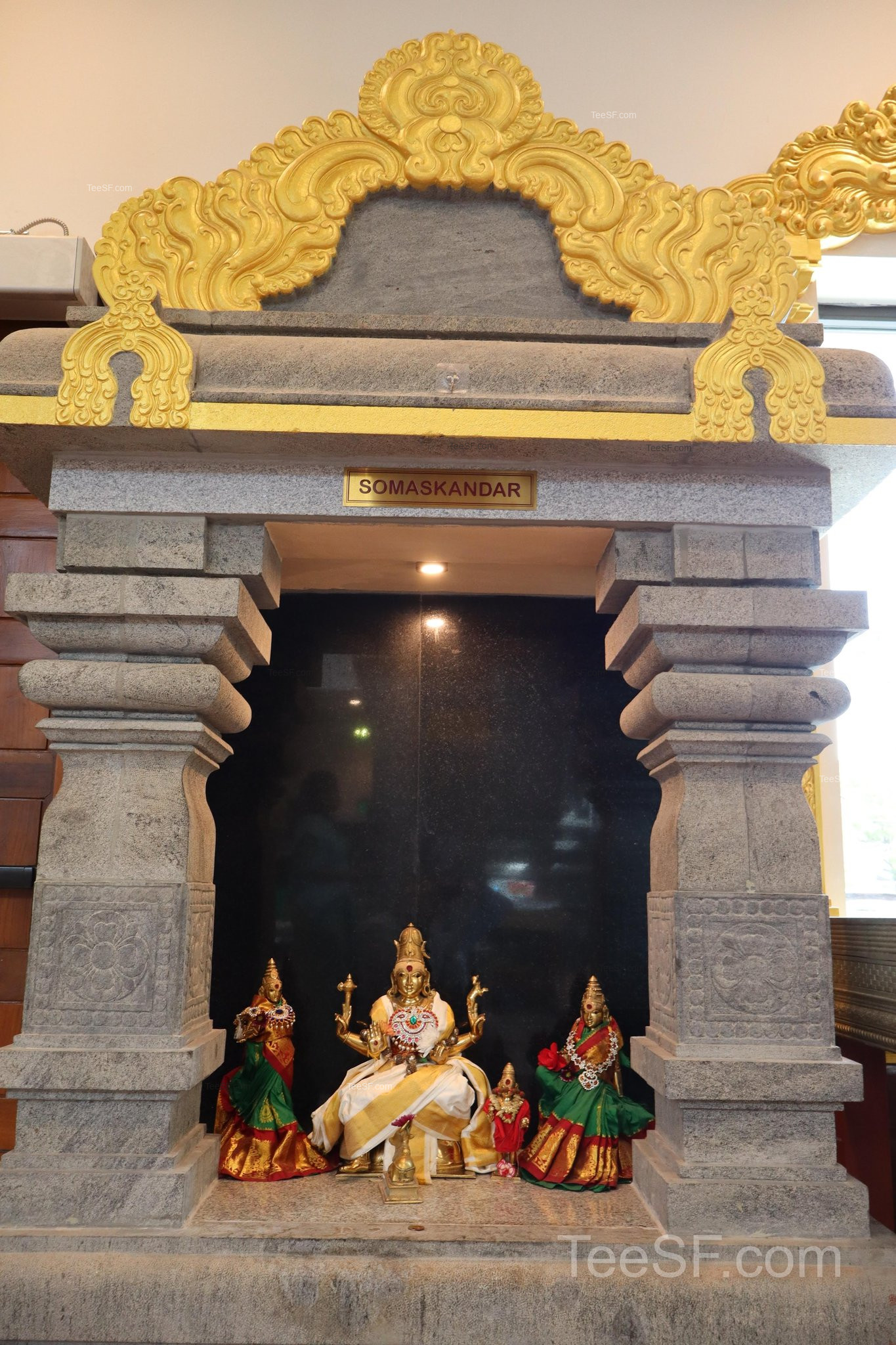A small temple niche shrine with figures arranged near the entrance.